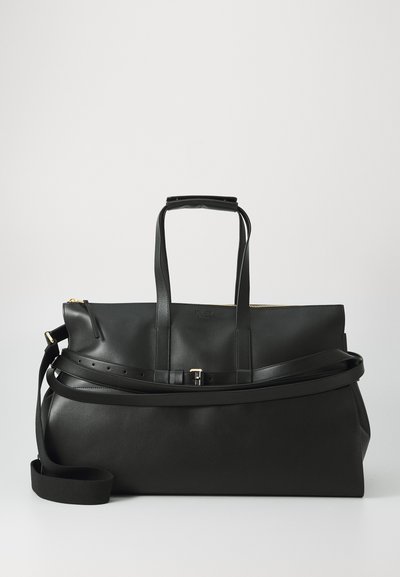 Black leather travel bag with dual top handles, adjustable shoulder strap, gold zipper, and smooth texture. Features a minimalist design.