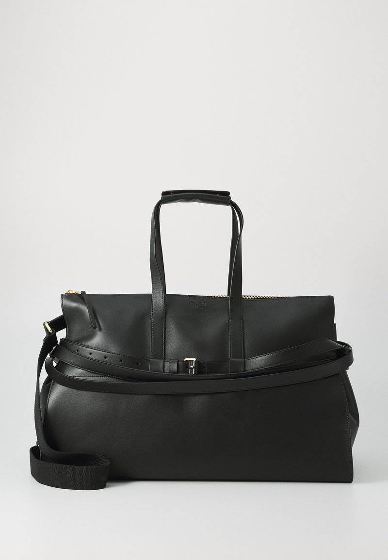 Melnas ādas ceļojumu soma ar divām augšējām rokturēm, regulējamu plecu siksnu, zelta rāvējslēdzēju un gludu tekstūru. Tam ir minimalistisks dizains.