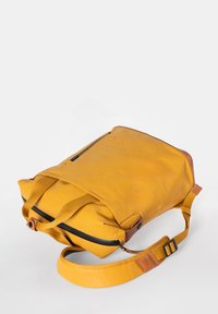 Gelbes Leder-Rucksack mit verstellbarem Tragegurt, Klappdeckel und Reißverschlusstasche vorne. Verfügt über eine strukturierte Oberfläche und braune Lederakzente.