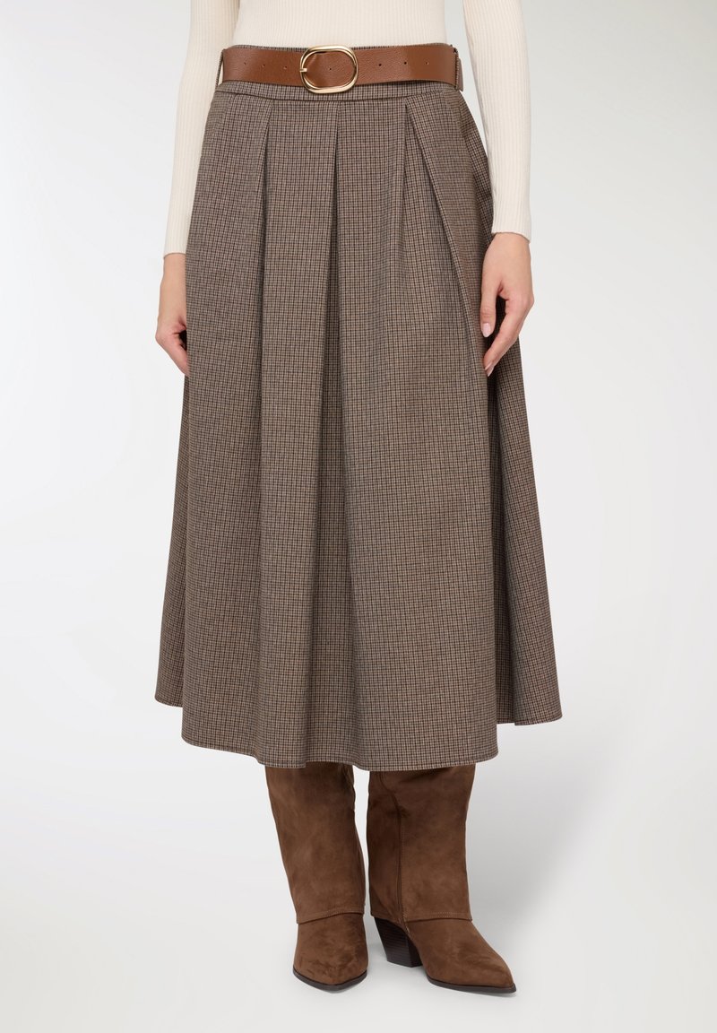 Gonna midi a quadri marroni con pieghe, dotata di cintura marrone con fibbia dorata, abbinata a stivali marroni in camoscio al ginocchio.