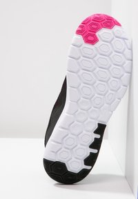 Černá atletická podrážka s hexagonálním vzorem. Bílé a růžové akcenty poblíž paty a mezipodešve s křivkovým designem.