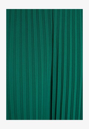 Vihreä kangas, jossa kapeat pystysuorat laskokset luovat pinnalle teksturoidun, tasaisesti jakautuneen kuvion.