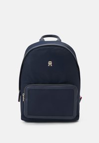 Zaino navy realizzato in tessuto resistente, con una texture liscia, un compartimento principale con zip e una tasca frontale con zip e dettaglio del logo.