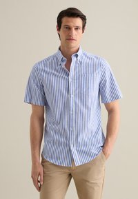 Camisa de botones de manga corta a rayas en azul y blanco, fabricada con tejido ligero. Cuenta con un collar y un bolsillo en el pecho. Corte casual.