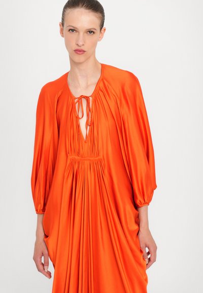 Vestido largo naranja hecho de tela suave, con un escote en V profundo con cierre de lazo, mangas abullonadas y detalles fruncidos en la cintura.