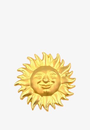 Decorazione solare dorata con un volto sorridente. Presenta raggi appuntiti e una superficie liscia, che riflette la luce in modo efficace.