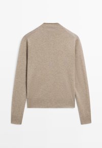 Beżowy kardigan z długim rękawem wykonany z miękkiej dzianiny; posiada okrągły dekolt i prążkowane mankiety, cechuje się minimalistycznym krojem i brakiem widocznych szwów.