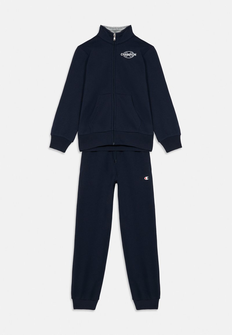 Chándal Champion en azul marino con chaqueta con cremallera que presenta el logo en el pecho, y joggers a juego con el logo en el muslo izquierdo.
