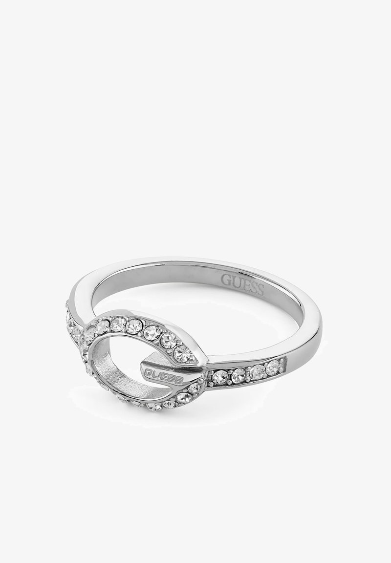 Bague en argent avec un design en boucle décorée de cristaux clairs et le nom de la marque "Guess" gravé à l'intérieur et sur la boucle.