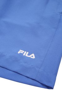 Siniset urheilushortsit, jotka on valmistettu sileästä kankaasta ja joissa on valkoinen logo. Suunnittelussa on siistiä ommelta ja klassinen leikkaus.