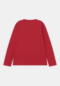 Red long-sleeve shirt made of cotton, featuring a round neckline and a smooth texture with a straightforward design and no visible patterns.
