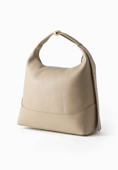 Μπεζ δερμάτινη τσάντα χειρός με ρυθμιζόμενο λουρί και αγκράφα σε χρυσό τόνο, σε στυλ χαλαρού γνήσιου, σε λευκό φόντο.