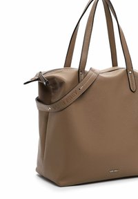 Brown leather tote bag with a textured finish, featuring dual handles and a detachable strap, accented with silver hardware and logo detail.