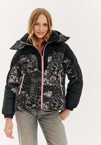 Czarna pikowana kurtka z kwiatowymi wzorami w odcieniach różu i bieli, z zamkiem błyskawicznym z przodu, regulowanym kapturem i mankietami na rękawach. Lekka i ciepła.