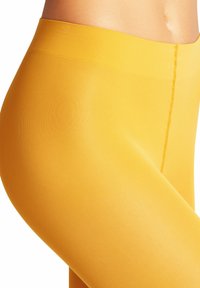 Leggings gialli realizzati in materiale liscio ed elastico. Presentano un'alta vita e una sottile texture a coste, con cuciture piatte per il massimo comfort.