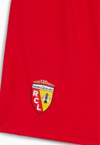 Červené sportovní šortky vyrobené z texturované tkaniny, s řádem Racing Club de Lens na žluto-červeném štítu a číslem "120" nad ním.