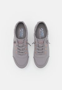 Šedé textilní tenisky s texturovaným svrškem, šněrováním, očky v růžovém zlatě a polstrovanými paměťovými stélkami. Bílé gumové podešve.