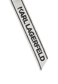 Sølvbånd med en glat finish, der har fed sort tekst "KARL LAGERFELD." Enderne er tilspidsede, hvilket er velegnet til forskellige stylingmuligheder.