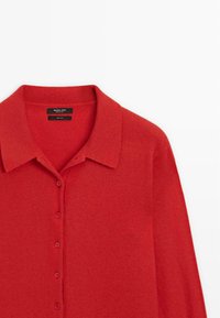 Červený vlněný kardigan s límečkem, s předním zapínáním na knoflíky a hladkou texturou. Štítek uvádí "Massimo Dutti, 100% vlna."