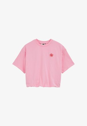 Roze korte mouw crop top met ronde hals en een kleine rode geborduurde bloem op de linkerborst.