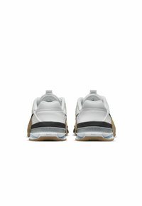 Sapatilhas brancas desportivas com um calcanhar preto, um upper texturizado e uma sola de borracha com um detalhe em azul claro e castanho.
