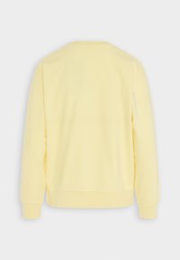 Sudadera amarilla con cuello redondo, mangas largas y una textura suave. Presenta puños y dobladillo acanalados, sin logotipos ni diseños visibles.