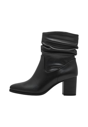 Bottine noire en cuir avec un haut affaissé, un bout pointu et un talon bloc empilé. Texture lisse avec un design minimaliste.