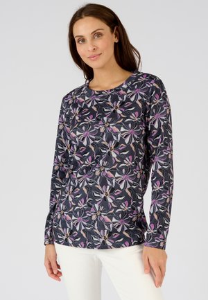 Camicia a maniche lunghe di colore blu navy con motivo floreale in viola, rosa e crema. Caratterizzata da un collo tondo e tessuto morbido e testurizzato.