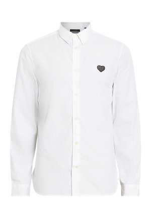 Witte blouse met lange mouwen van katoen, met een button-down kraag en een zwart hartlogo geborduurd op de linkerborst.