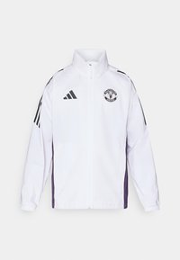 Hvid jakke med Manchester United-logo, med sorte og lilla accenter. Lavet af glat, letvægtsmateriale, med høj krave og lynlåslukning.