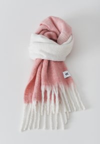 Sciarpa morbida e lavorata a maglia con una sfumatura che va dal rosa chiaro al bianco, con bordi frangiati e un piccolo etichetta su un lato.