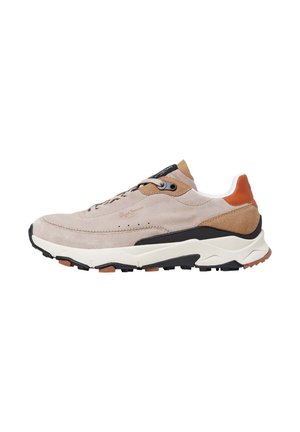 Zapatilla de ante beige con acentos marrones, suela negra, diseño con cordones y detalles texturizados. Presenta una media suela blanca acolchada.