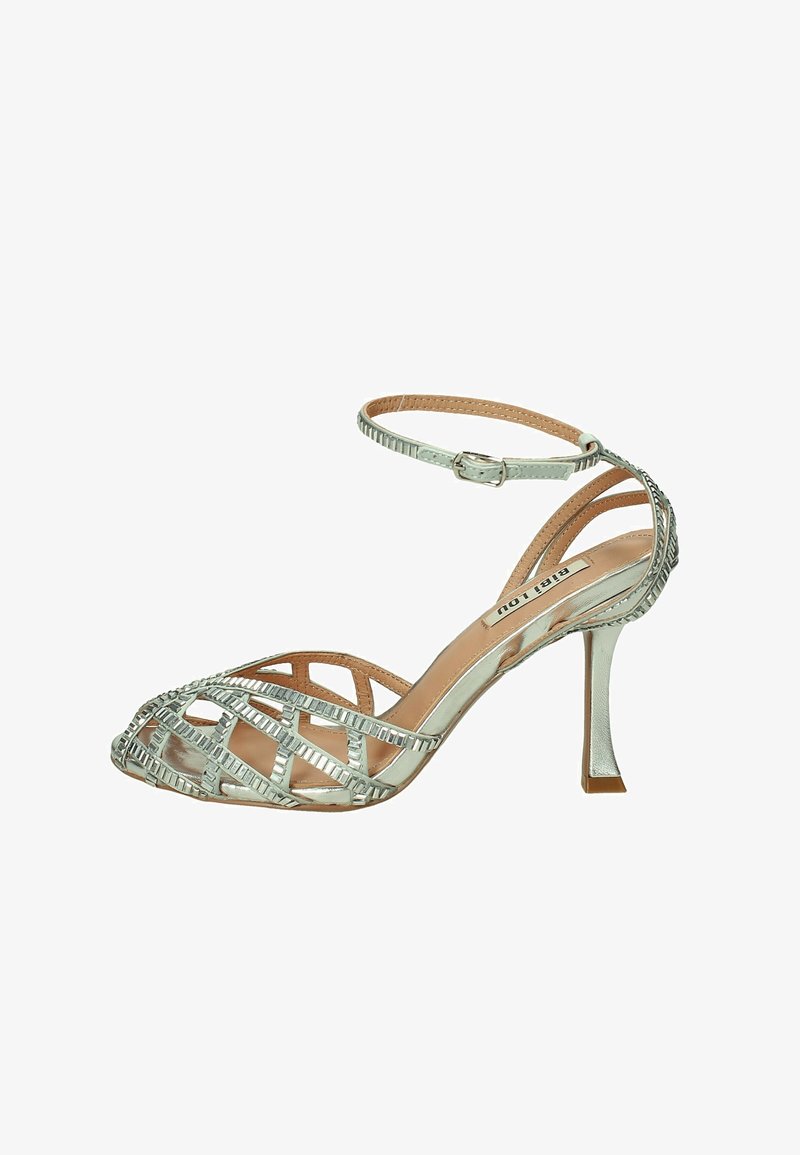 Sandalo stiletto aperto in punta di argento con design a cinturini incrociati, fibbia alla caviglia e finitura lucida. Presenta un tacco sottile e dettagli testurizzati.