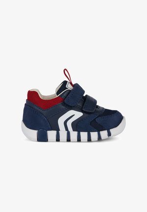 Scarpe sportive blu navy con accenti in rete rossi, logo bianco e cinturino in Velcro. Presentano una tomaia texturizzata e una suola bianca segmentata.