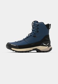 Zils pārgājienu zābaks ar teksturētu augšdaļu, melnu zoli un pastiprinātu purngalu. Aprīkots ar auklām un izteiksmīgu logotipu sānos.