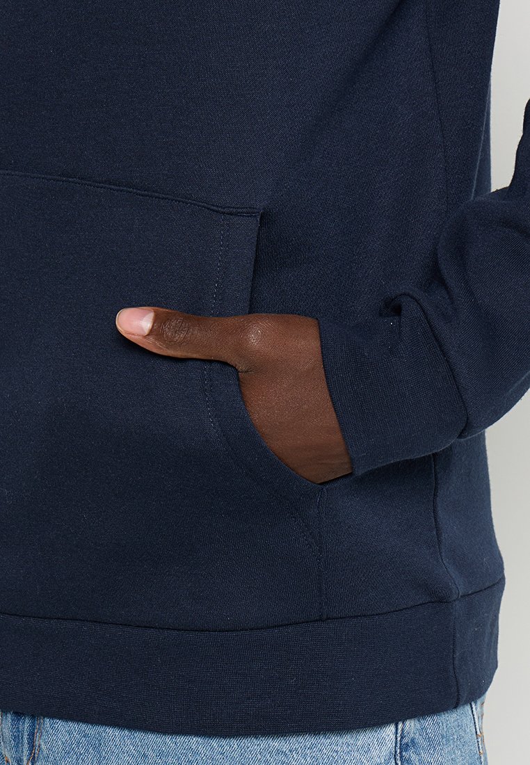 Granatowy hoodie z kieszenią kangurką, miękką teksturą, elastycznymi mankietami i luźnym krojem, z widocznymi detalami szwów.