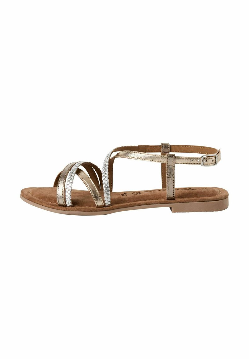 Sandali piatti metallici dorati con cinghie intrecciate, una soffice soletta marrone e chiusura con fibbia. La suola è piatta e testurizzata per una migliore aderenza.