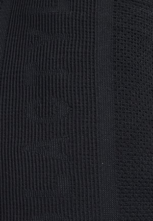 Zwart gebreide stof met duidelijke geribbelde en textuurpatronen, die verschillende breistijlen toont en een uniforme kleur heeft.