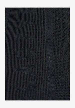 Tessuto a maglia nera con distintivi motivi a coste e texture, che mostrano diversi stili di maglieria e un colore uniforme in tutto il materiale.