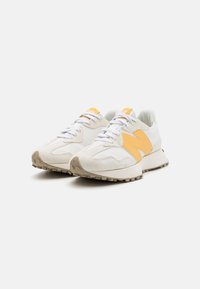 Sneaker mit einem weißen Textil-Obermaterial, orangefarbenem N-Logo, beigem Wildleder-Zehenbereich und strukturiertem Gummi-Außenboden für Griffigkeit.