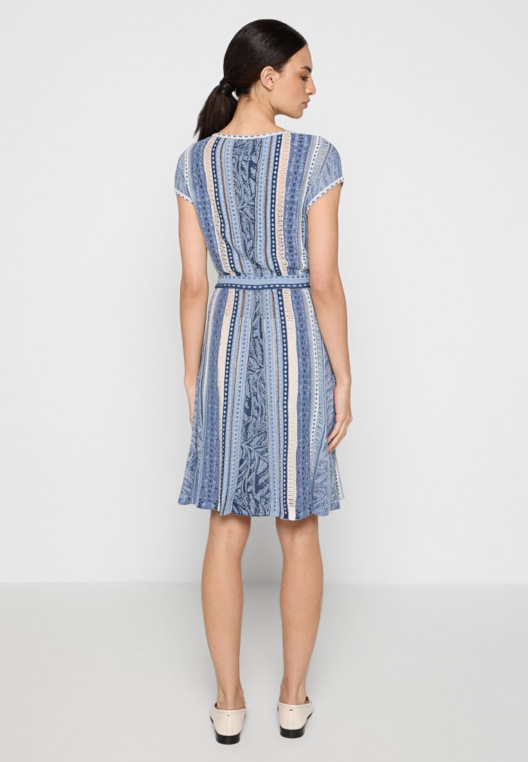 Un vestito blu a fantasia con vita aderente, maniche corte e una gonna svasata con strisce e motivi floreali.