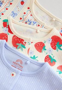 Trois hauts pour bébés avec des boutons à thème de fraise ; les motifs incluent des fraises, des cœurs, des fleurs et des nœuds dans des couleurs pastel et vives.