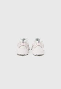 Pari valkoisia ja vaaleanpunaisia urheilukenkiä nähtynä takaa valkoisella yksivärisellä taustalla, korostaen kantapään ja pohjan muotoilua.