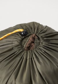 Olivegrønne pouch lavet af glat nylon med en fluffy brun indvendig foring. Har en sort snorlås og gul snor til lukning.