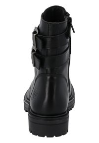 Botas de tobillo de cuero negro con tres correas ajustables y hebillas de plata, que cuentan con un cierre lateral y una suela de goma texturizada.