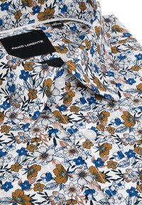 Biała koszula w kwiaty z niebieskimi, pomarańczowymi i zielonymi kwiatami oraz liśćmi. Posiada kołnierz typu spread, zapinanie na guziki oraz subtelną teksturę. Widoczna metka marki.