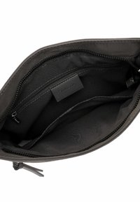 Pochette en tissu noir avec fermeture éclair. L'intérieur est doté d'une doublure lisse, d'une poche zippée supplémentaire et d'une étiquette de marque.