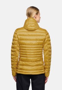 Gelbe Pufferjacke mit Kapuze, gestepptem Design, leichtem Material und geripptem Stoff. Verfügt über eine taillierte Silhouette und Reißverschlüsse.