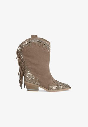 Brązowe zamszowe kowbojki z wycięciami, frędzlami z tyłu oraz niskim obcasem w kształcie bloku. Ozdobne wzory wzdłuż krawędzi.