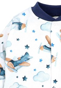 Katoenen romper met een lichte achtergrond en verspreide patronen van vliegtuigen en sterren in blauw, oranje en wit. Marineblauwe kraag en drukknoopjes.